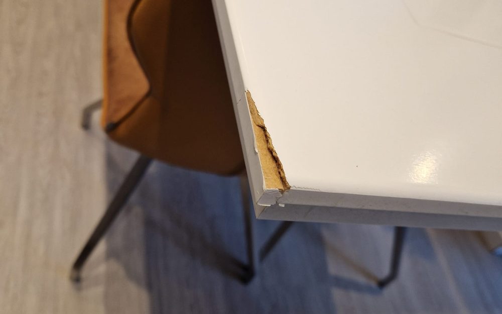 Wit hoogglans paneel met een afgebroken rand, in een kantoor